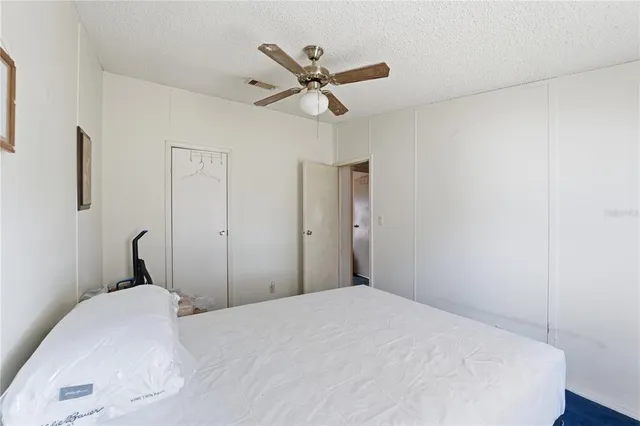 a bedroom with a large bed and a chandelier