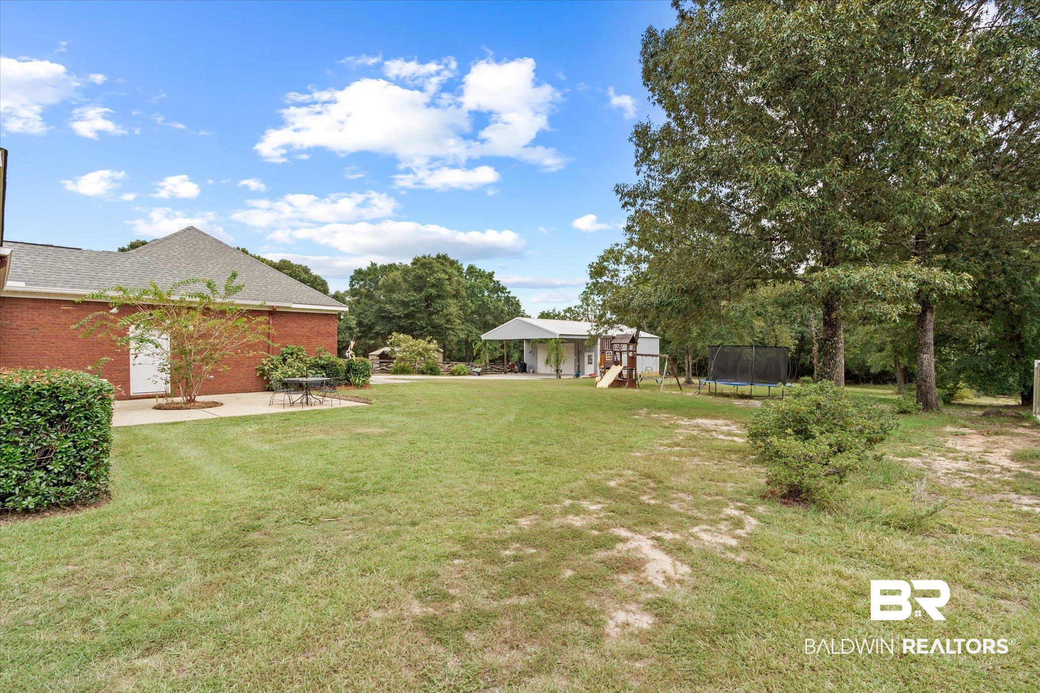8840 Celeste Road Saraland, AL 36571 - Photo 25 of 43 View of yard with a playground, a patio, and a trampoline