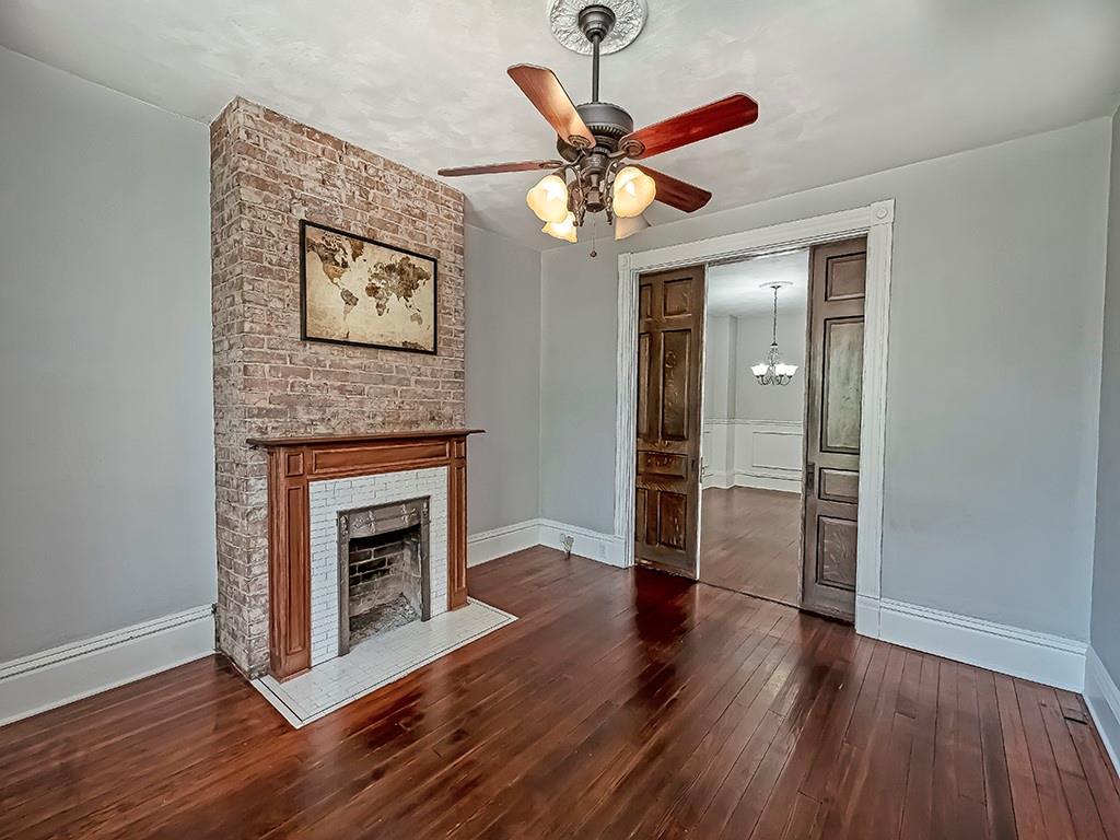 449 Library Avenue Carnegie, PA 15106 - Photo 5 of 22 an empty room with wooden floor a ceiling fan a fireplace and windows