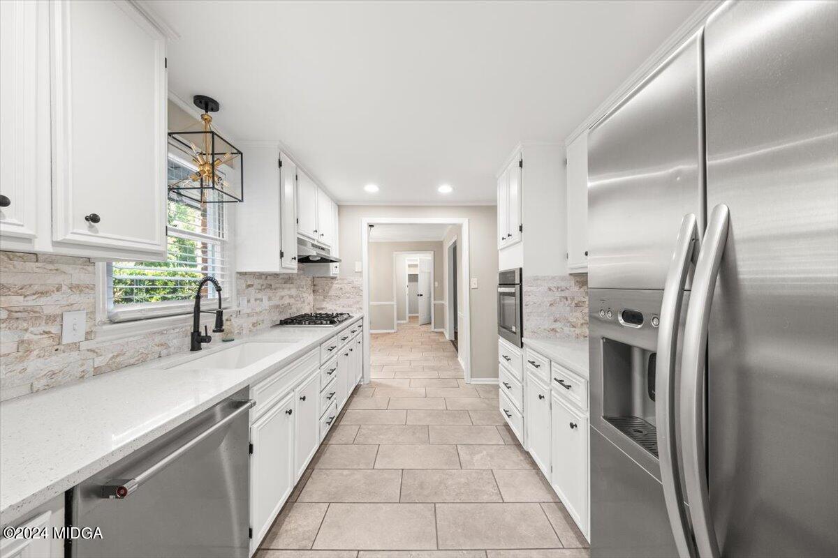 a large kitchen with a large counter top stainless steel appliances and a sink