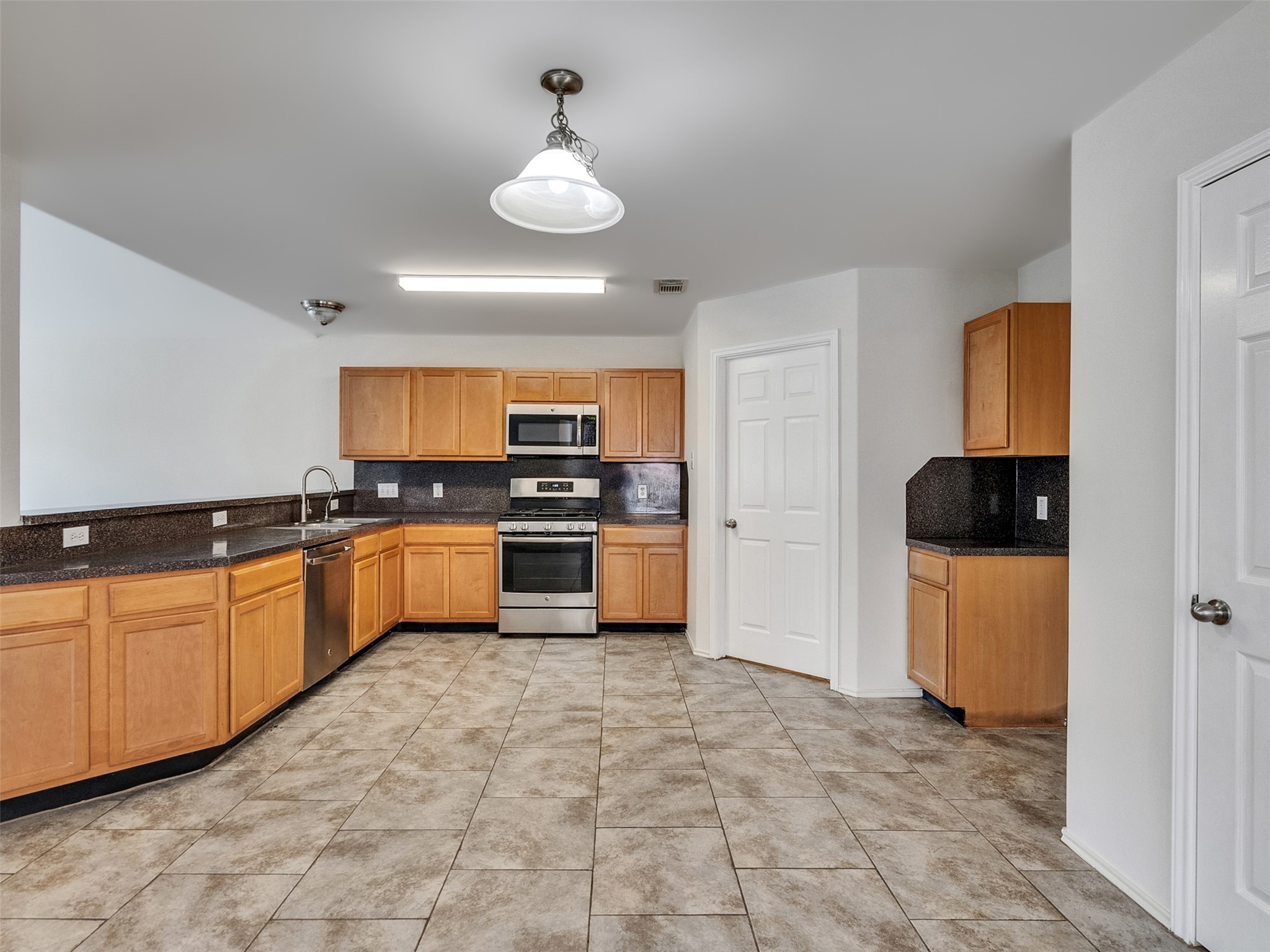 13431 Rural Oak Street Houston, TX 77034 - Photo 7 of 24 a large kitchen with stainless steel appliances granite countertop a stove a sink and a refrigerator