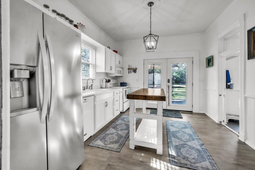 911 Highway 85 Connector Brooks, GA 30205 - Photo 11 of 45 a kitchen with stainless steel appliances kitchen island granite countertop a refrigerator a sink a stove and white cabinets with wooden floor