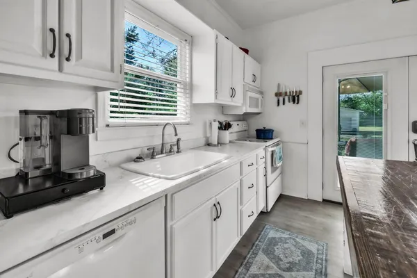 a kitchen with granite countertop stainless steel appliances a sink stove and cabinets