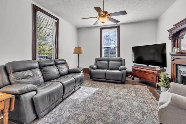 a living room with furniture a ceiling fan and a window