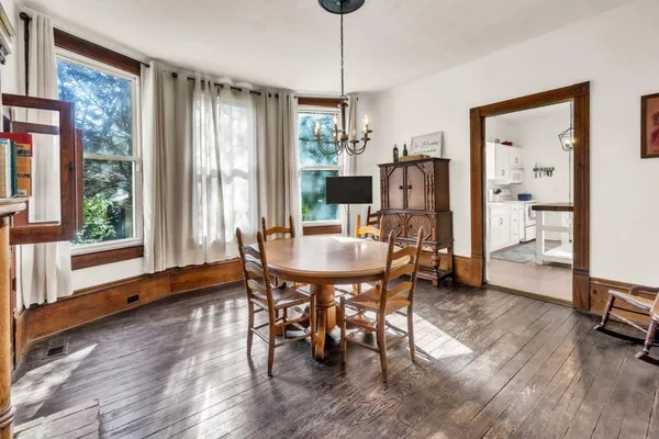 a dining room with furniture window and wooden floor