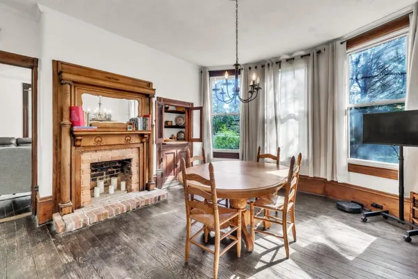 a dining room with furniture a chandelier and wooden floor