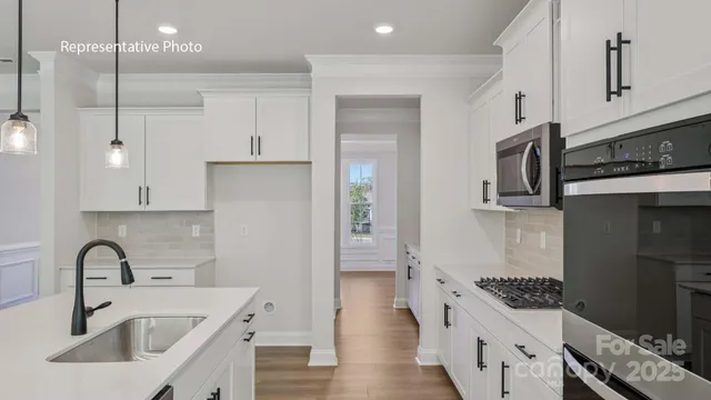 a kitchen with kitchen island stainless steel appliances a sink a stove and a refrigerator