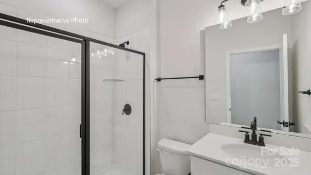 a bathroom with a granite countertop sink a toilet and shower