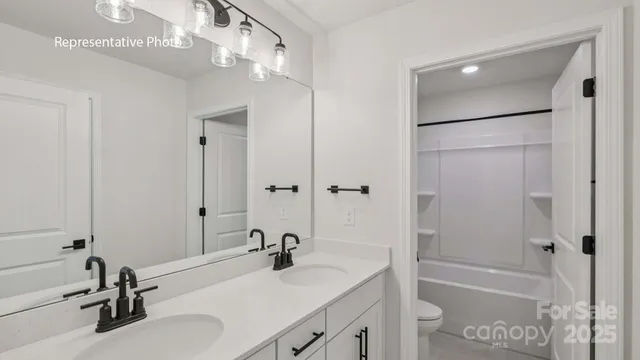 a bathroom with a granite countertop sink a mirror and a bathtub