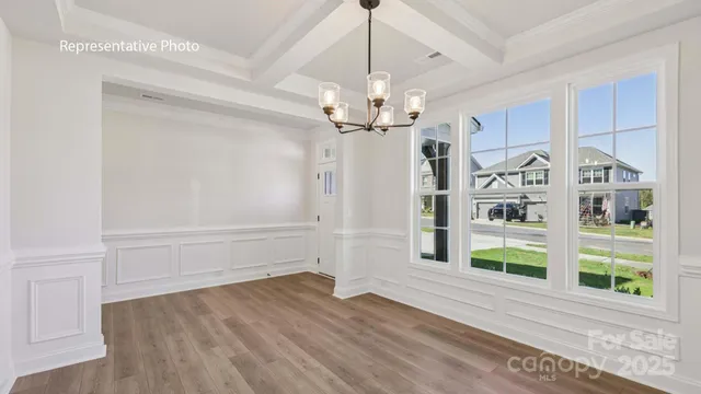 a view of a hallway with wooden floor and chandelier