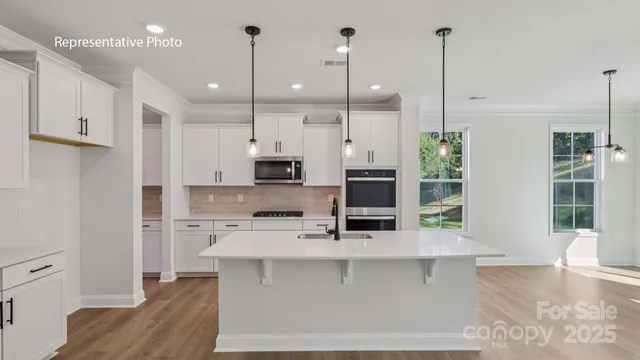 a kitchen with stainless steel appliances kitchen island granite countertop a stove a sink and a refrigerator