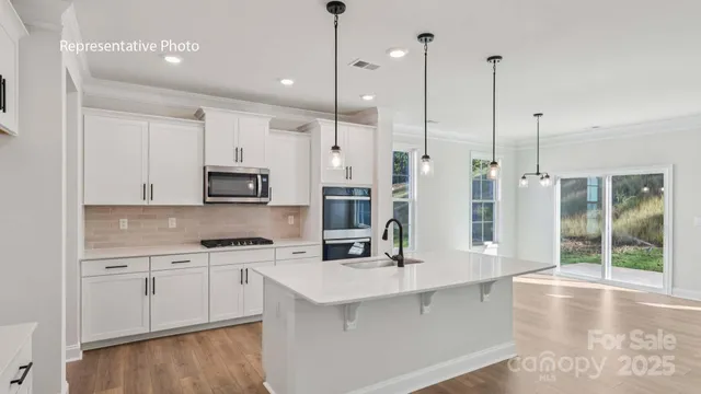 a kitchen with stainless steel appliances kitchen island granite countertop a sink a stove and cabinets