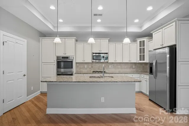 a kitchen with kitchen island a sink stainless steel appliances and cabinets