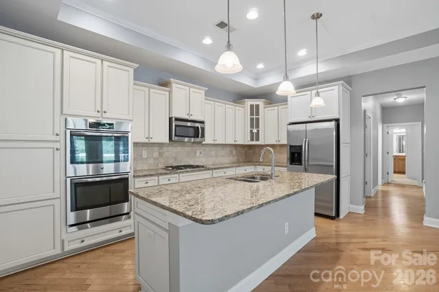 a kitchen with a center island a counter space stainless steel appliances and cabinets