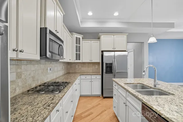 a kitchen with granite countertop a sink cabinets and wooden floor