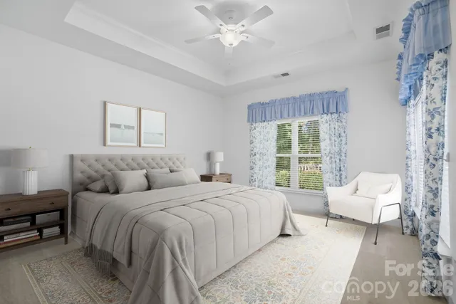 a bedroom with a bed couches and a flat tv screen