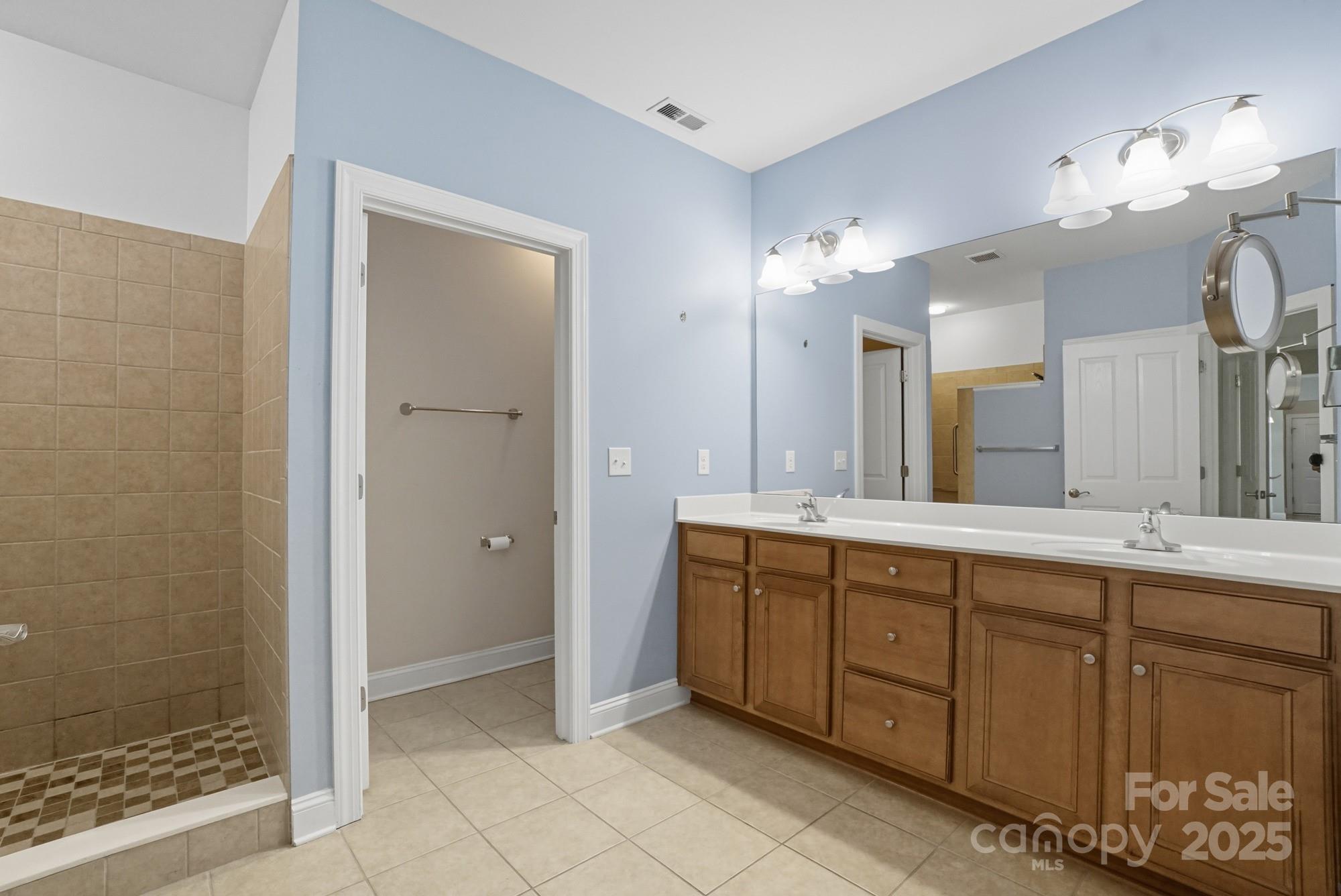 2232 Coltsview Lane Matthews, NC 28105 - Photo 24 of 42 a spacious bathroom with a double vanity sink a large mirror and shower
