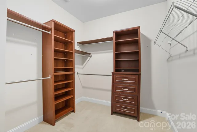 a view of walk in closet with empty racks