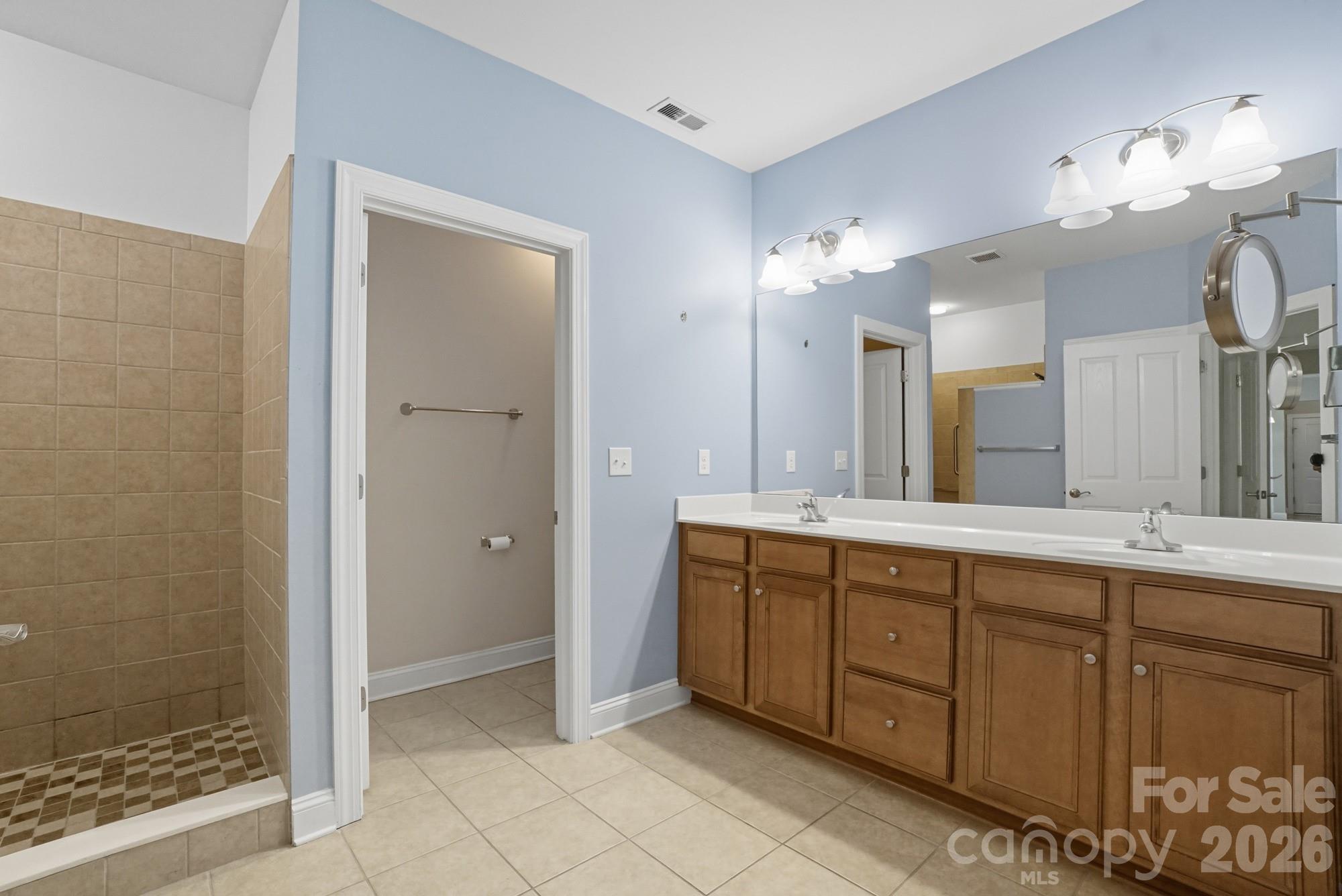 2232 Coltsview Lane Matthews, NC 28105 - Photo 28 of 47 a spacious bathroom with a double vanity sink a large mirror and shower