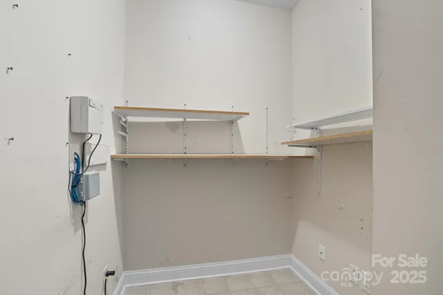 a view of a house with a floor to ceiling window and wooden fence