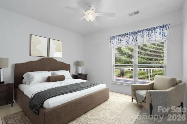 a bedroom with a large bed and a couch next to a window