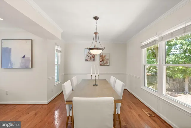 a view of a dining room and livingroom with furniture wooden floor a chandelier