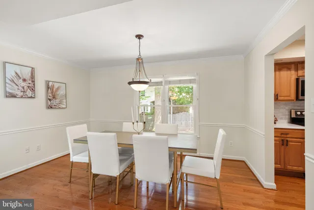 a kitchen with stainless steel appliances granite countertop a refrigerator a sink dishwasher a stove and white countertops with wooden floor