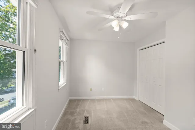 an empty room with a window and a fan