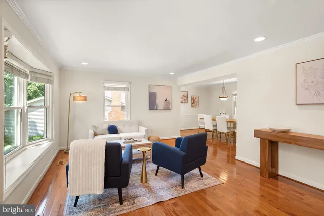 a living room with furniture wooden floor and a large window