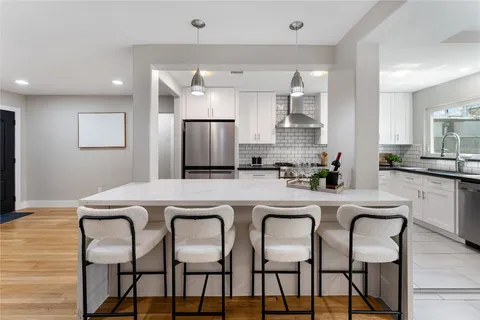 a kitchen with granite countertop a stove a sink and a refrigerator