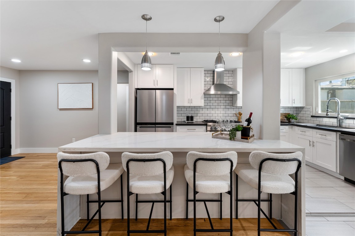 6623 Housman Houston, TX 77055 - Photo 7 of 38 a white kitchen with a dining table chairs refrigerator and cabinets