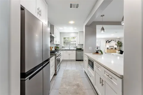 a living room with furniture and a dining table with garden view