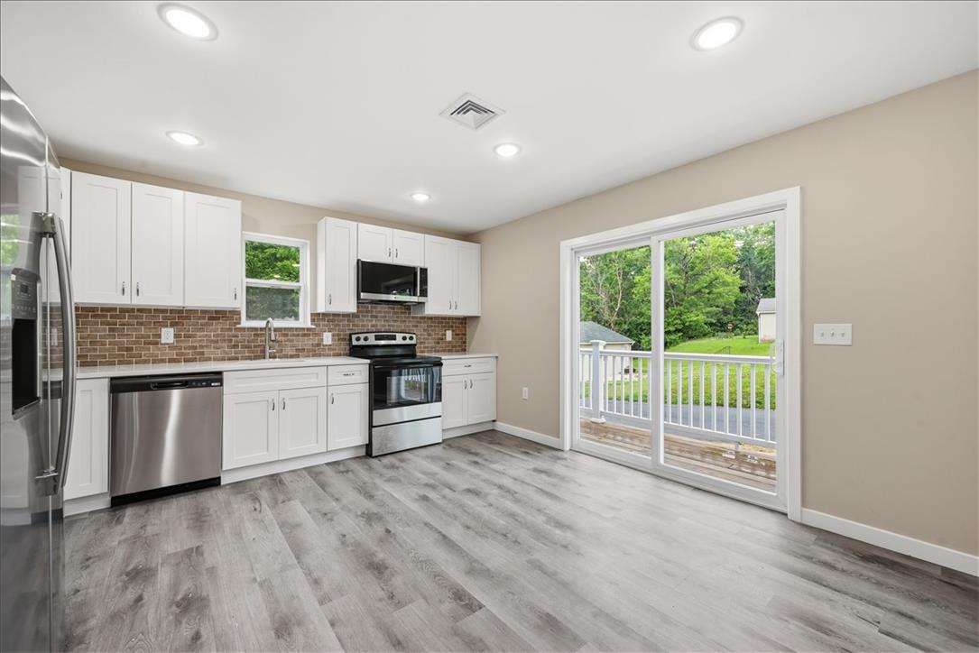 5641 North Coplay Road Whitehall, PA 18052 - Photo 9 of 68 A well-lit kitchen with modern appliances and light-colored flooring opens to a serene outdoor space.