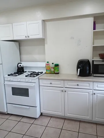 a kitchen with white cabinets and white appliances