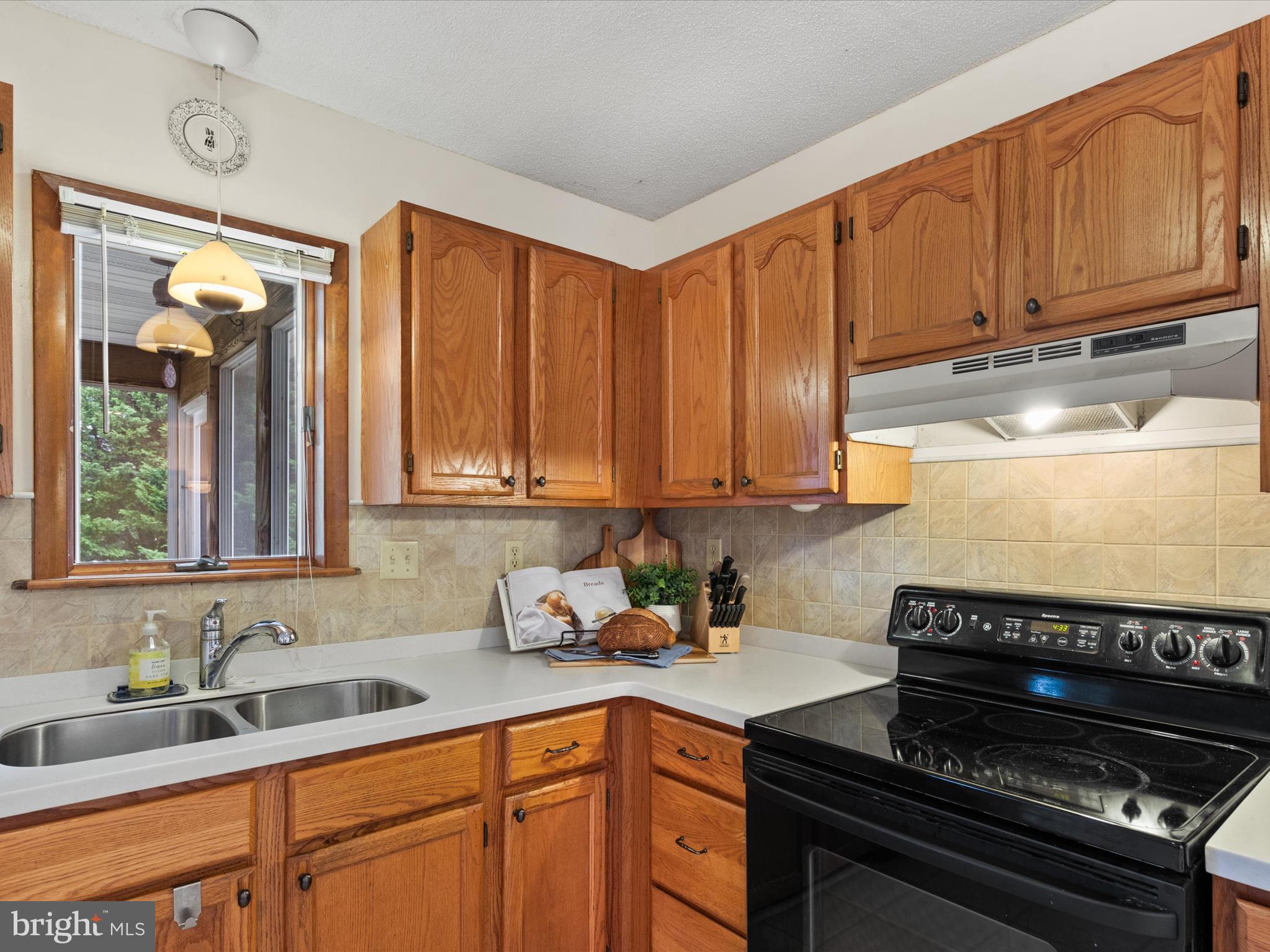 13374 Cove Landing Road Bishopville, MD 21813 - Photo 20 of 108 a kitchen with granite countertop a stove a sink and dishwasher wooden cabinets with a granite countertops