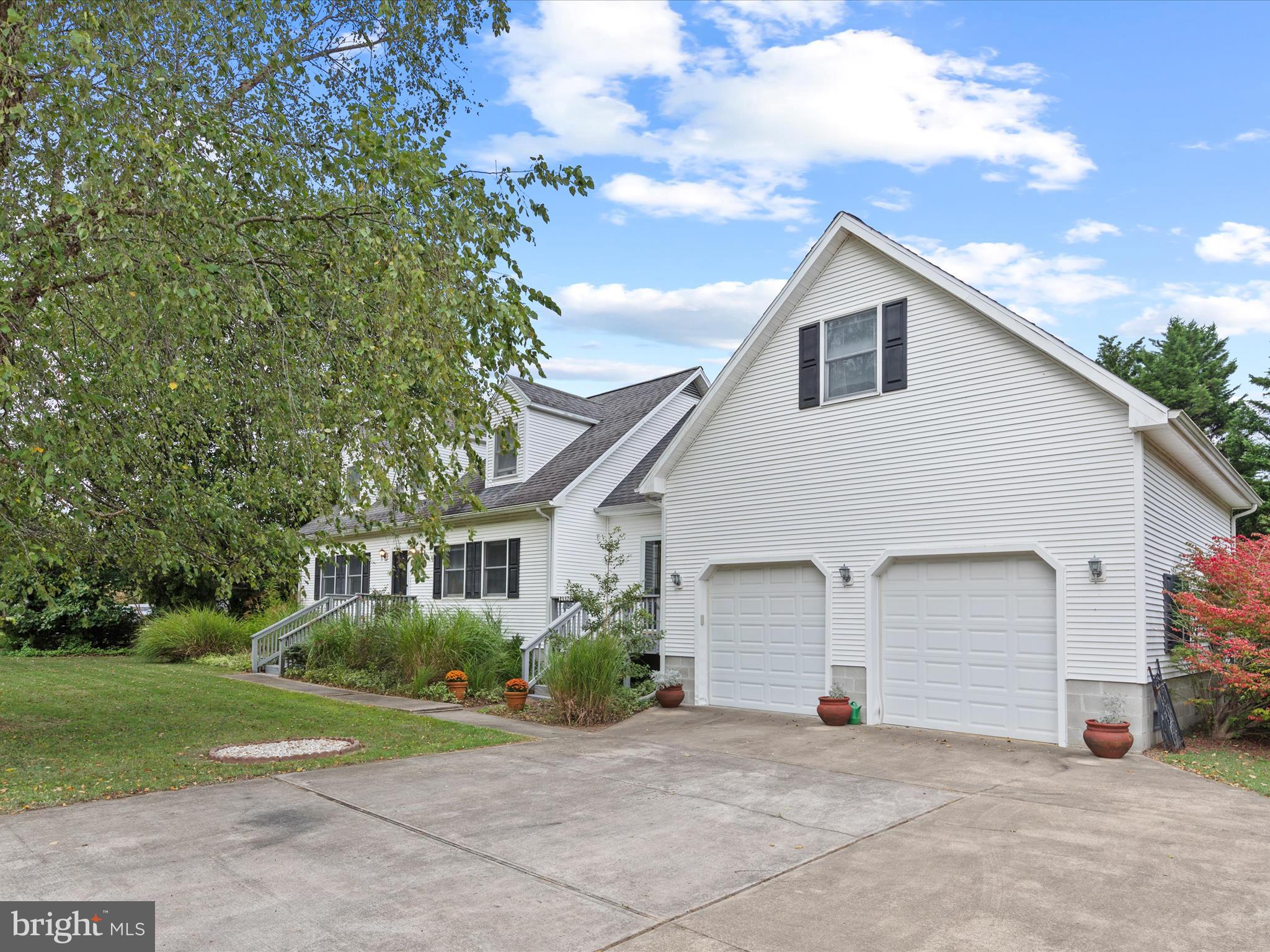 13374 Cove Landing Road Bishopville, MD 21813 - Photo 6 of 108 a view of a white house next to a yard and large trees