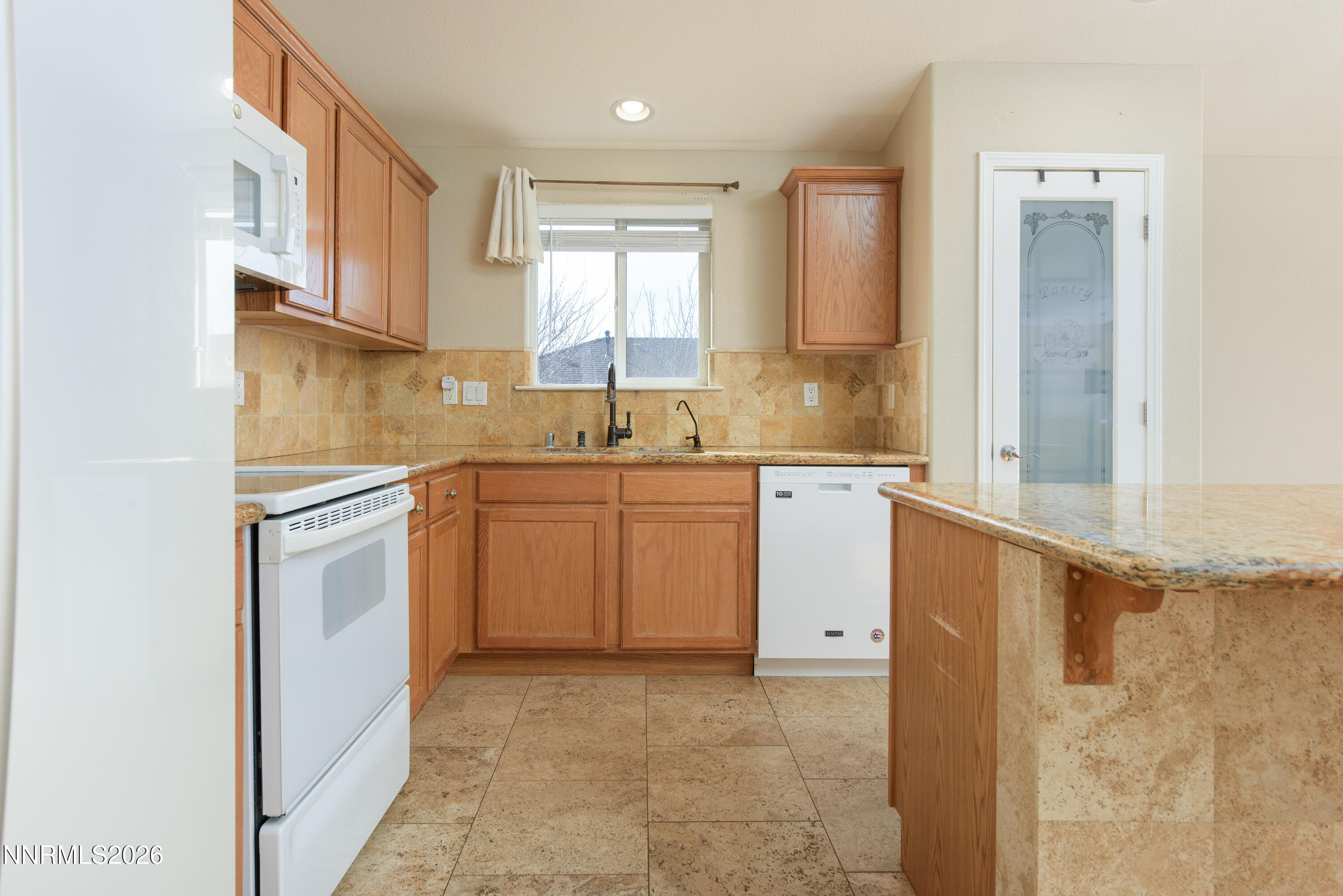 44 Conner Way Gardnerville, NV 89410 - Photo 15 of 38 a kitchen with a sink a stove cabinets and a window