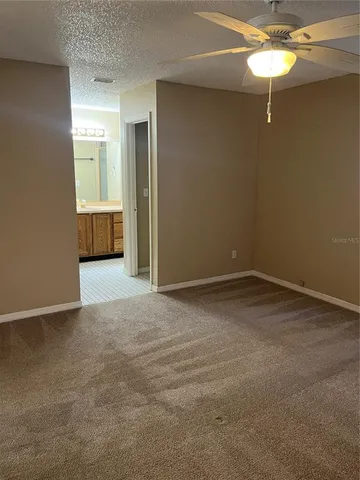 a view of a room with a hanging light and hardwood