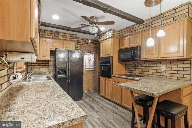 a kitchen with stainless steel appliances granite countertop a sink a stove and refrigerator