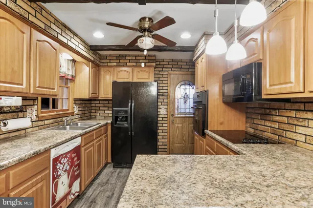 a kitchen with stainless steel appliances granite countertop a sink a stove and a refrigerator
