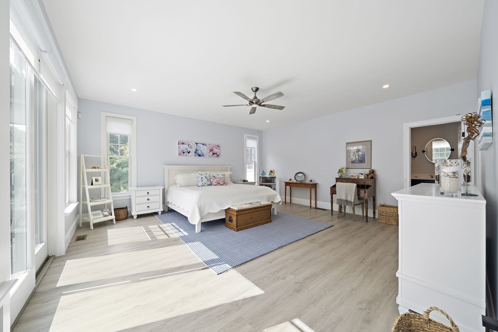 53 Border Street Scituate, MA 02066 - Photo 11 of 34 a spacious bedroom with a bed a table and a potted plant
