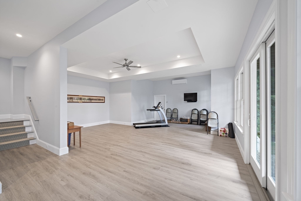 53 Border Street Scituate, MA 02066 - Photo 22 of 34 a view of a livingroom with a flat screen tv wooden floor and a ceiling fan