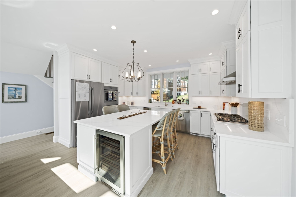 53 Border Street Scituate, MA 02066 - Photo 8 of 34 a large kitchen with cabinets a sink a stove a refrigerator and a dining table with wooden floor