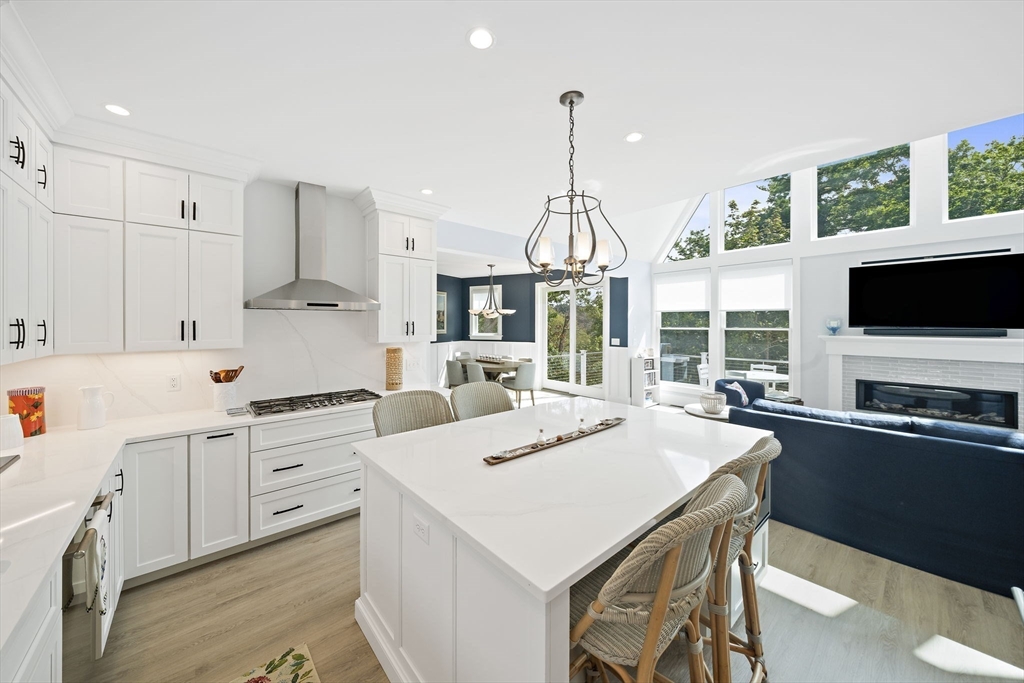 53 Border Street Scituate, MA 02066 - Photo 9 of 34 a kitchen with stainless steel appliances kitchen island granite countertop a sink a stove and a refrigerator