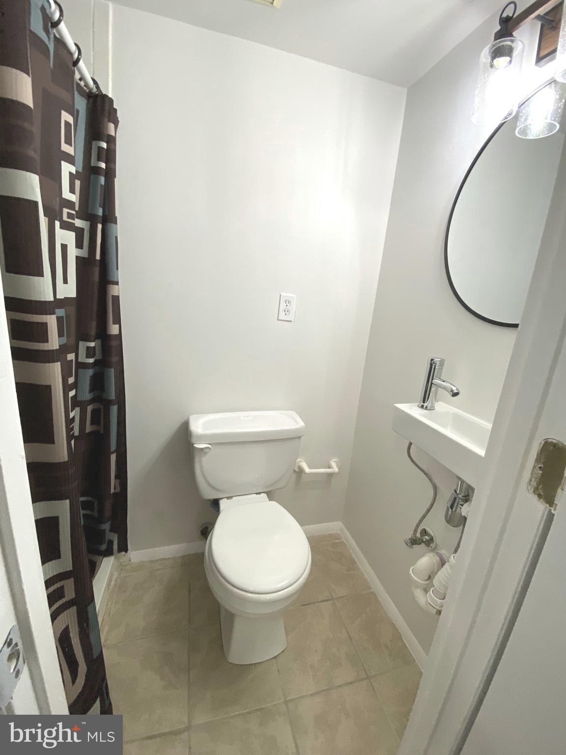 15947 Dorset Road, Unit 188 Laurel, MD 20707 - Photo 19 of 24 a white toilet sitting next to a bathroom sink and a mirror
