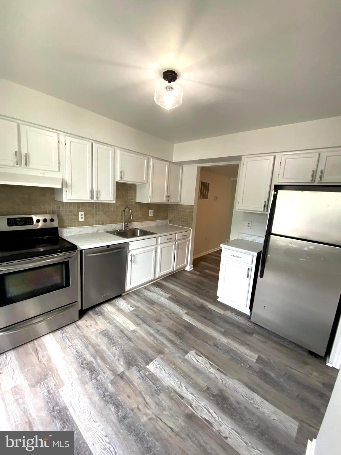 15947 Dorset Road, Unit 188 Laurel, MD 20707 - Photo 4 of 24 a kitchen with a refrigerator a sink and a stove top oven