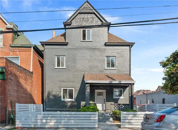 a front view of a house with a garden