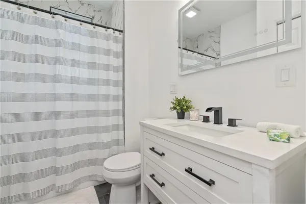 a bathroom with a sink a toilet and shower curtain