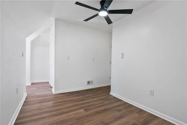 a view of an empty room with wooden floor