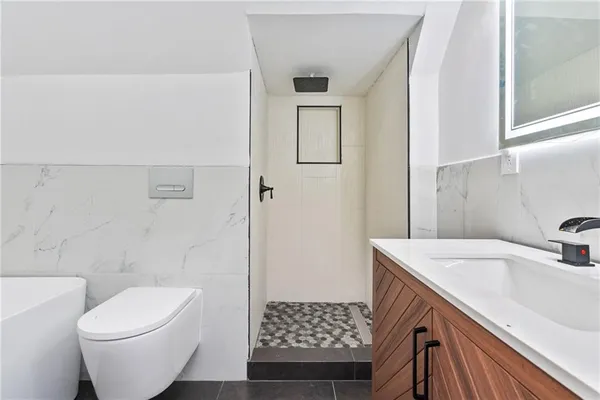 a bathroom with a sink a toilet and shower